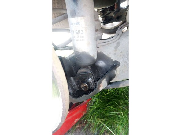 A l'aide d'un chasse goupille, venir expulser la vis en tapant légèrement dessus de l'autre côté et ainsi, libérer l'amortisseur de sa vis inférieure.