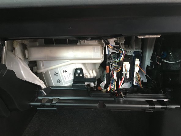 Serrer les deux coté de la boite à gant pour la sortir de son logement