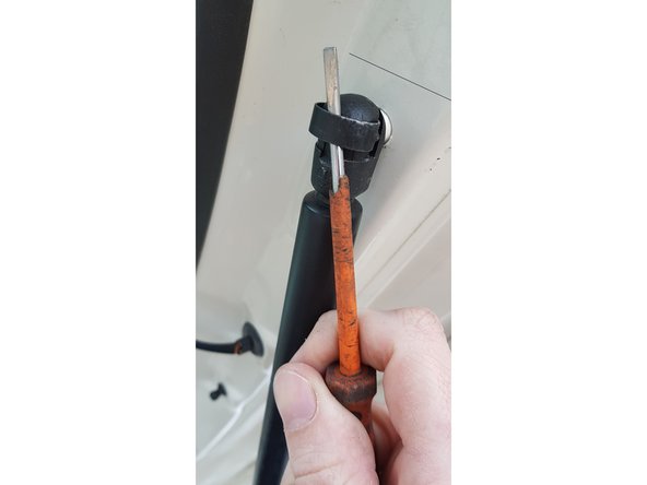 Avec une main maintenez le hayon et avec l'autre retirez l'agrafe.