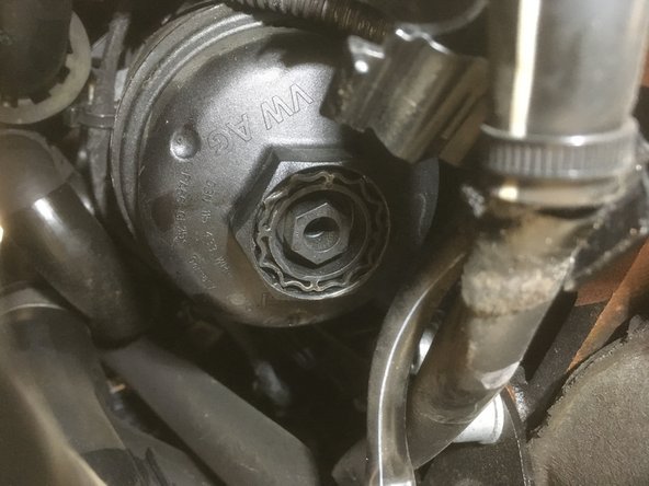 Remonter le sur le moteur en commençant le serrage à la main et en  le terminant avec le cliquet