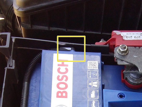 Déposer les écrous sur la cosse positive, à l'aide d'une clé de 10, puis écarter la patte et le boitier de protection de la batterie avec précaution