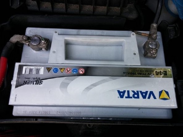 Reposer ensuite la batterie en prenant soin de ne pas inverser les polarités . Le + coté gauche ( fil rouge ) et le - coté droit ( fil noir). Re visser la patte de fixation de la batterie .  Reposer ensuite le cache derrière l'optique de phare et le cache supérieur ( ils se clipsent entre eux )