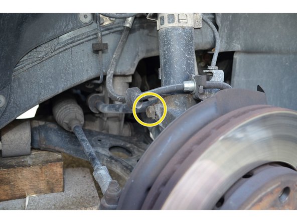 Un seul boulon maintient la partie inférieure de l'amortisseur.