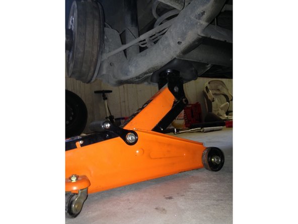 À l'aide d'un cric, soulever légèrement le train arrière sous le ressort pour soulager la pression.