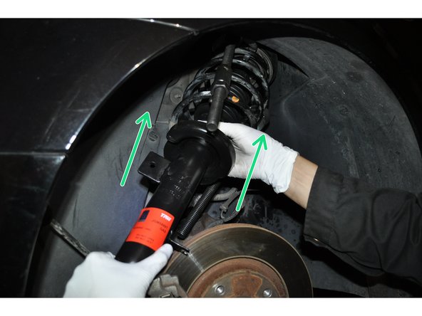 Engager l'élément de suspension dans le passage de roue, en centrant son palier supérieur à l'aide du pion de centrage.