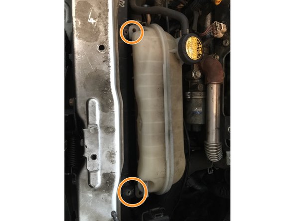 Déposer le réservoir de liquide de refroidissement. 2 boulons aux extrémités du réservoir. clé à pipe de 10.