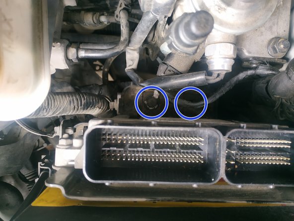 dévisser la vis de maintien du support calculateur, clé de 10mm