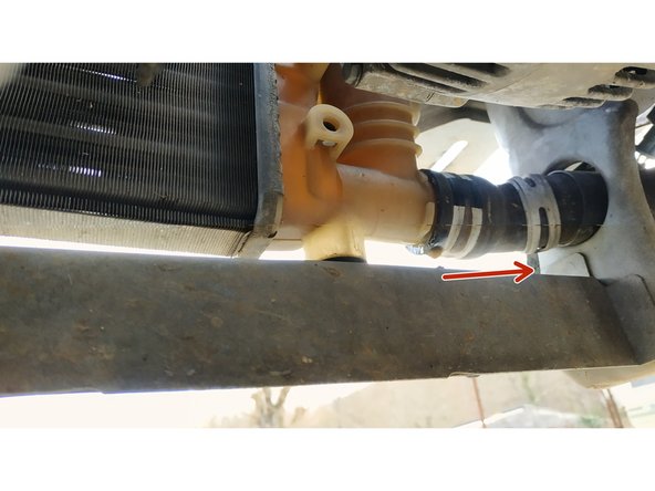 libérer le collier de serrage de la durite inférieure à l'aide d'une pince multiprise