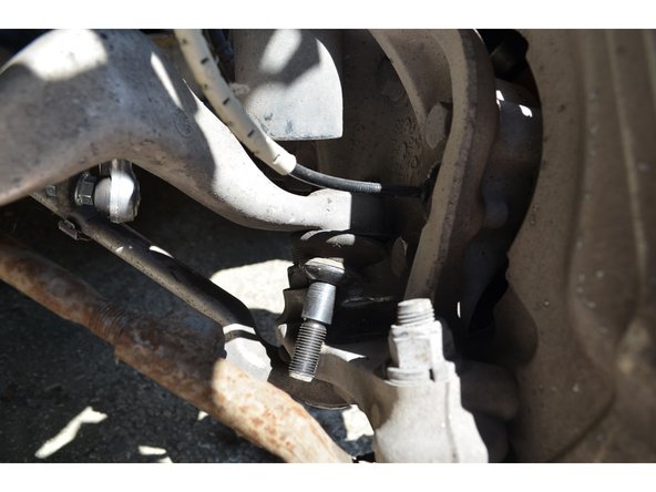 Avec le maillet tapez sur le tirant de chasse côté châssis pour le faire sortir.