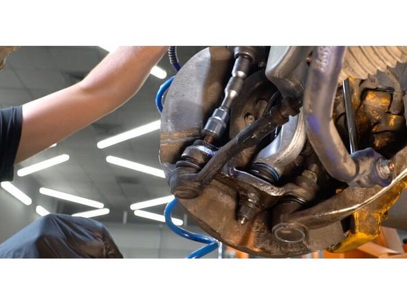 Dévissez l'écrou d'attache d'extrémité à la fusée d'essieu. Utilisez une douille n° 21. Utilisez une clé à cliquet.