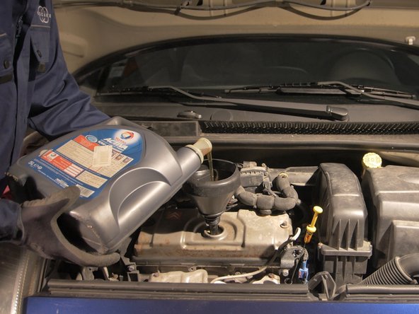 Verser environ 3l d'huile moteur à l'aide d'un entonnoir