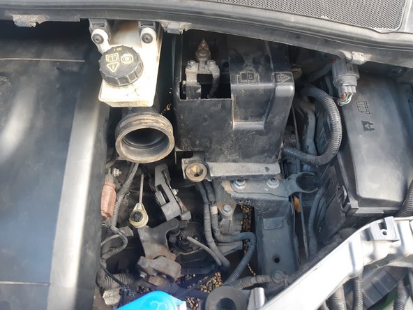 Le fond de la boite de filtre à air est simplement clipser en trois points (2 à gauche, 1 à droite). Si vous le tirer vers le haut vous devez pouvoir le dé-clipser. Ensuite il faut bouger cette partie en plastique afin de pouvoir l'extraire.