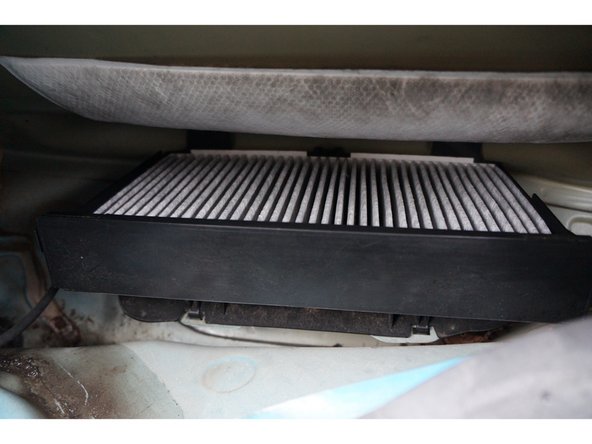 Mettre le nouveau filtre en place respectant le sens de montage(flèche sur le fitre vers le bas) ,  puis refermer.