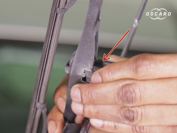 Retenir à la main l'attache et faire glisser le balai d'essuie glace afin de le retirer en le glissant vers le haut