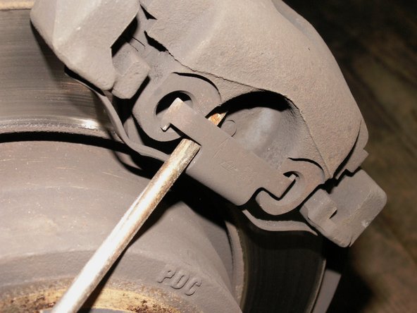 Retirer le ressort en faisant levier avec un tournevis plat.