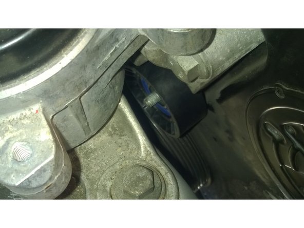 Il suffit ensuite de mettre le nouveau galet de la meme façon. La pièce ronde, le galet (si ça coince un peu, écarter le moteur avec un pied de biche de quelque mm). Enfin mettre la rondelle (la reclipser) et visser l'écrou.