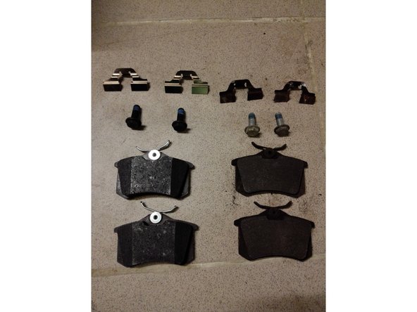 Photo 2: On compare également les plaquettes de frein, les vis de colonette et les adaptateurs métalliques qui servent à caler les plaquettes dans l'étrier. A gauche, les pièces neuves et à droite les pièces usagées.