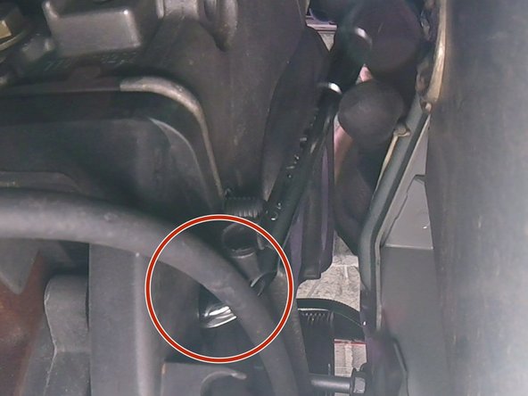 Retirer les deux vis du haut du carter en plastique avec une clé de 10 (ici la seconde vis en haut à gauche)