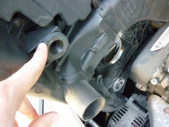 Replacez le cache moteur en rebranchant la durite du reniflard et en alignant les clips par rapport aux fixations.