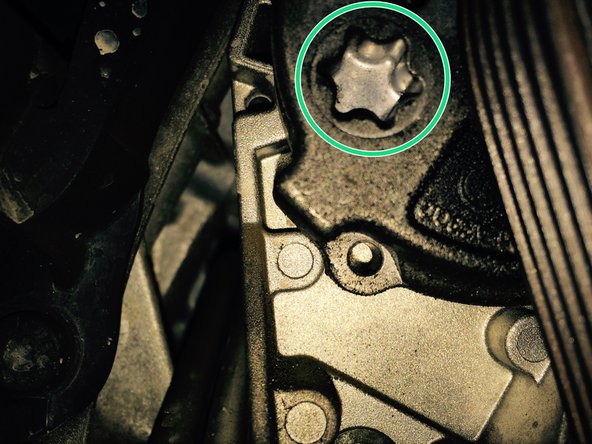 La courroie est montée avec un tendeur à ressort. Il est nécessaire de faire pivoter le galet tendeur vers l'avant de la voiture afin de pouvoir glisser une clé allen (par exemple) dans le trou de blocage du tendeur.