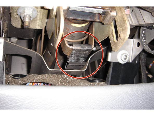 On récupère le clip métallique de la demi-coquille et on le place sur le support de la colonne de direction.