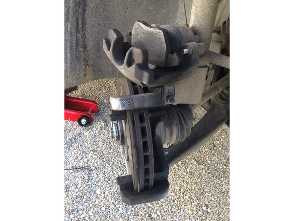 à l'aide d'un tournevis enlever le ressort qui maintien la partie mobile de l'étrier, retirer la partie mobile et la poser sur le dessus du disque