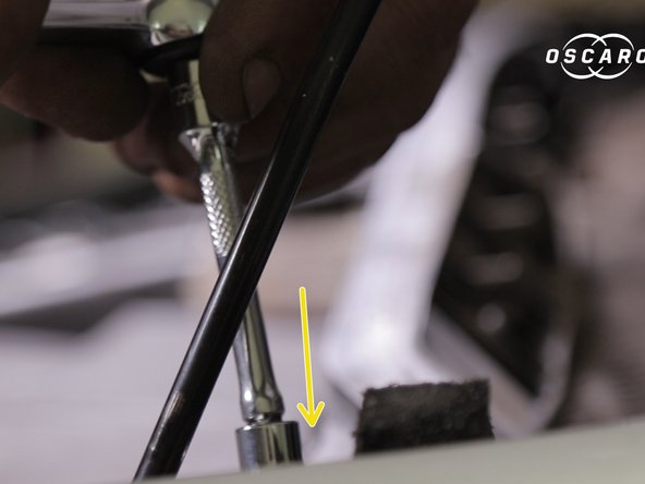 Replacer la traverse en plastique,l’insérer dans l'encoche  coté passager et visser la partie de la barre coté conducteur