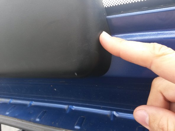 Appuyer fortement sur l'ergot droit du cache