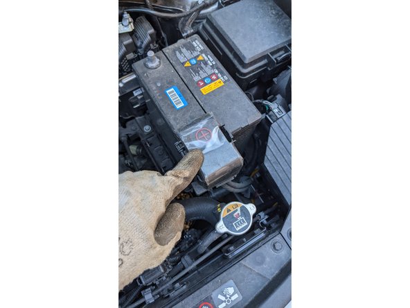 Identifier la borne + de la batterie et défaire un peu le boulon à l'aide d'une clef à pipe de 10. Ne pas dévisser complètement le boulon, juste le nécessaire pour enlever le contact de la borne +.