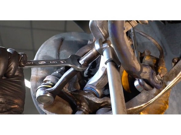 Serrez l'écrou de bloquage de l'extrémité de la barre. Utilisez une clé mixte de No.23 Utilisez une clé mixte de No.24 Utilisez une clé dynamométrique. Serrez-le jusqu'à 51 Nm.