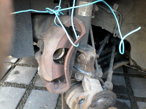 Suspendre l'étrier à l'amortisseur à l'aide d'un cable ou d'une corde