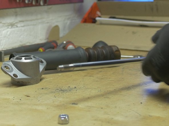 Retirer l'écrou présent sur la tige du nouvel amortisseur