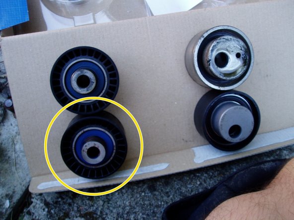 A l'aide d'une clé de 13, remonter le nouveau galet enrouleur vendu avec le kit (cercle jaune). Serrer à 43 N.m.