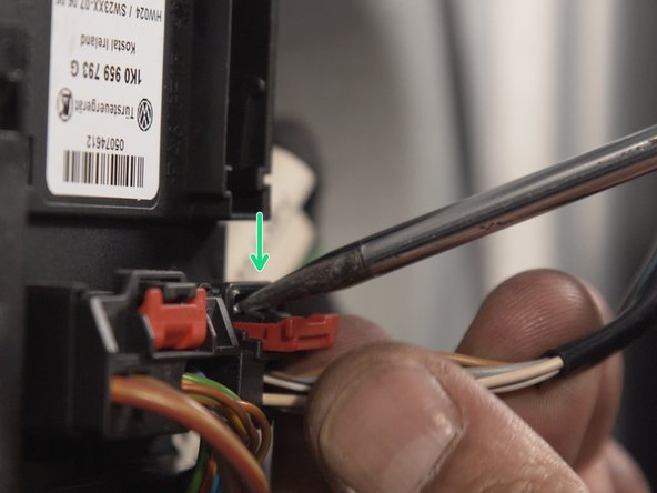 A l'aide d'un petit tournevis plat, déverouiller et tirer sur le connecteur de réglage du rétroviseur pour le déconnecter