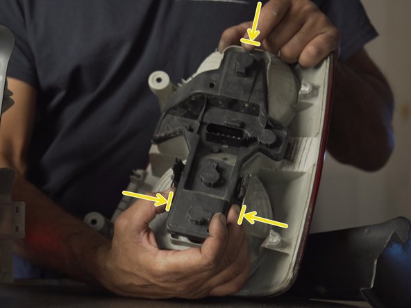 Retirer la platine de l'ancien feu en pressant les languettes de chaque côté de cette dernière