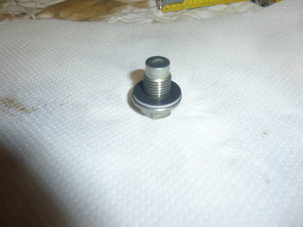 Une fois que vous avez  enlenvé le bouchon de vidange et le porte filtre, lever la voiture   enlever la chandelle, et remettre la voiture à plat pour que toute l'huile sortent du moteur, relever le véhicule placer de nouveau la chandelle.