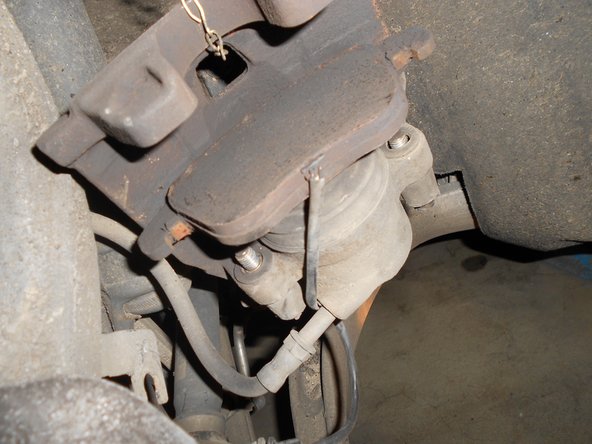 Maintenir l'ensemble pour ne pas endommager les durites. Puis enlever les plaquettes usées. Débrancher la fiche du témoin d'sure en lui faisant faire un quart de tour en sens horaire