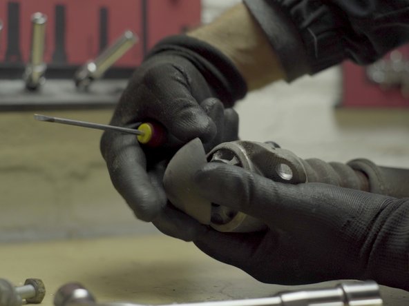 Faire levier avec un petit tournevis plat pour déposer le tête de la coupelle d'amortisseur