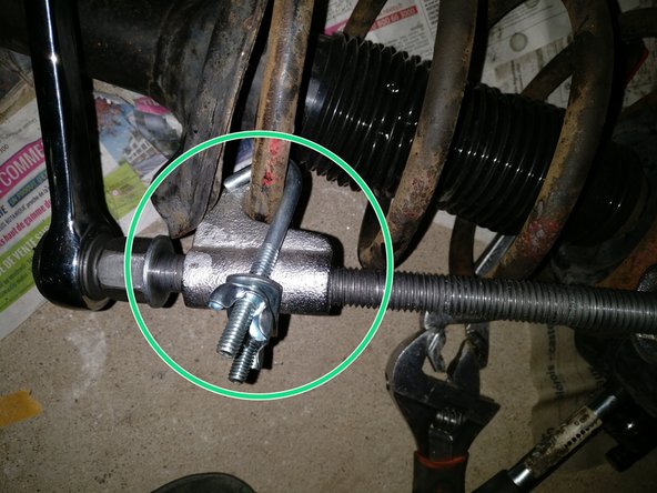 Mettre les griffes du compresseur de ressort sur les spires (en haut et en bas)