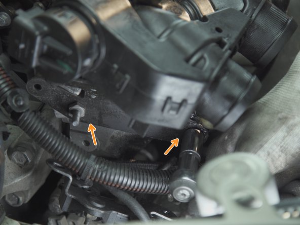 Dévisser les deux écrous présents sous la plaque précédemment retirée avec un cliquet et une douille de 13