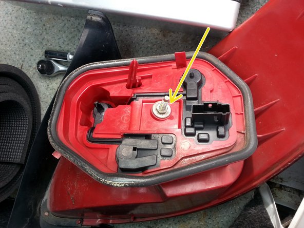 défaire l'écrou avec une clé de 10mm puis séparer la platine du feux en tirant dessus