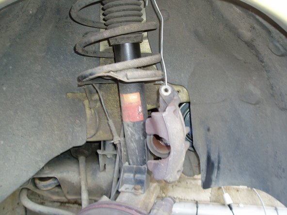 Suspendre l'étrier de frein en veillant à ne pas endommager le flexible à l'aide d'un fil de fer sur le ressort de suspension