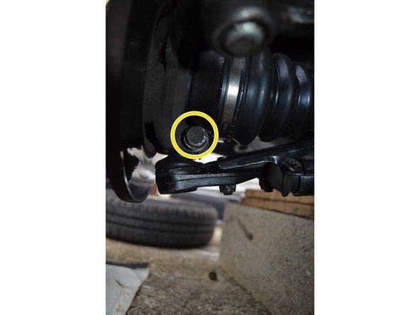 Maintenez l'écrou avec une clé à œil de 18mm.