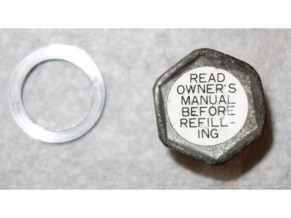 Terminer le dévissage à la main du bouchon de l'orifice de remplissage. Garder le joint.