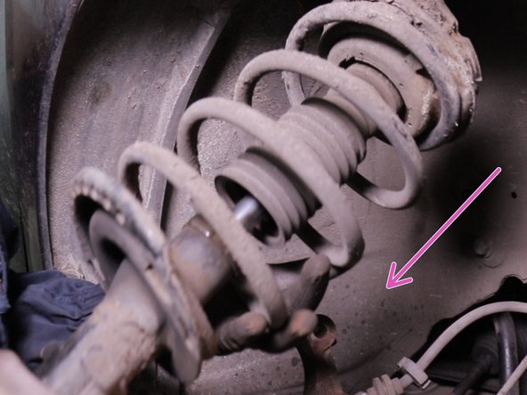 Retirer l'amortisseur en commençant par le bas puis le laisser descendre