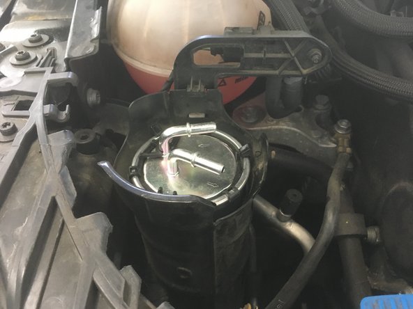 Pousser le vers le bas jusqu'a ce que les trois pattes de maintient soit par dessus le filtre