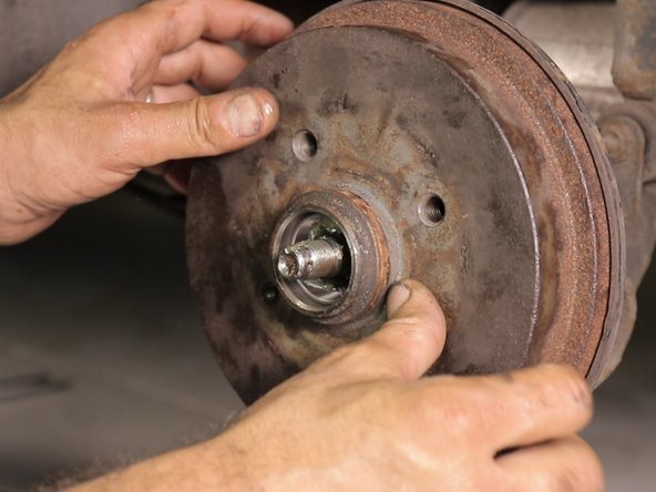 Reposez le tambour délicatement en guident le roulement intérieure sur la fusée d'essieu