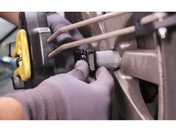 Appuyer sur le loquet métallique de la clé 6 pans intégrée et emboîter la clé de montage sur l'écrou universel au maximum jusqu'au retour du loquet en position haute.