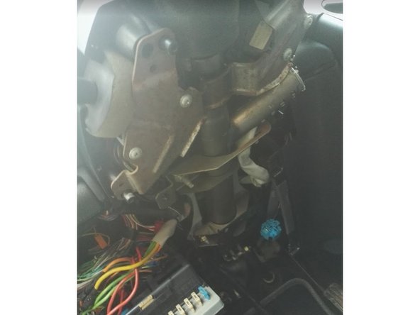 Dévisser les 4 vis de fixation de la demi coquille inférieure sous le volant, puis la déposer