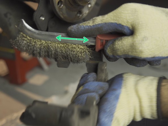 Brosser avec une brosse métallique pour nettoyer les dépôts de poussière de frein